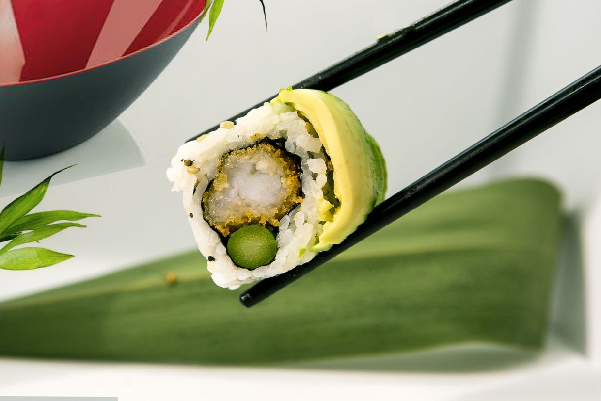 piece of avocado, chicken and cucumber sushi